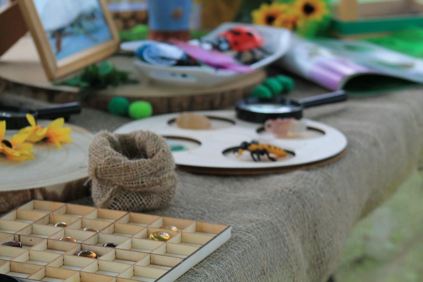 Vassoio per la scoperta della natura per bambini con gemme e lenti d'ingrandimento.